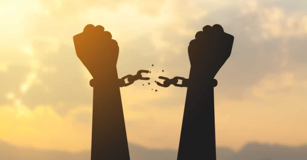 silhouette hand with chain is absent and blurred sky in sunrise background