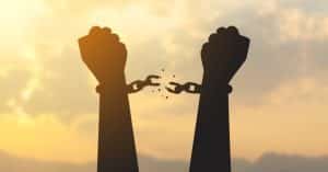 silhouette hand with chain is absent and blurred sky in sunrise background